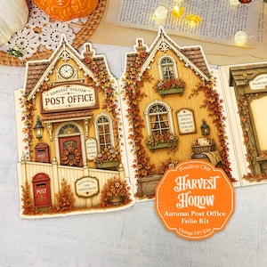 May include: A Harvest Hollow Autumn Post Office folio kit featuring two die-cut paper structures with yellow wood siding, autumn leaf vines, and red doors. The design includes a post office sign, a red mailbox, and a circular orange product label.