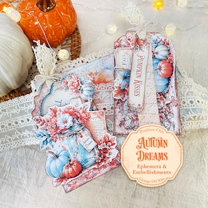May include: Decorative paper tags and ephemera featuring autumn themes, including pumpkins, mason jars with flowers, butterflies, and lace accents. Text on the items includes "PUMPKIN KISSES," "FALL," "Autumn Dreams," and "Positive Chic AUTUMN DREAMS Ephemera & Embellishments."