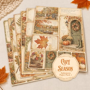 May include: A collection of decorative paper sheets featuring autumn-themed illustrations including pumpkins, maple leaves, floral wreaths, and rustic doorways. The pack includes a label with the text Positive Chic COZY SEASON Ephemera Paper Pack 1.