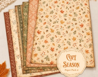 May include: A set of rectangular decorative paper sheets featuring various autumn-themed patterns including fall leaves, acorns, berries, and floral motifs in shades of orange, green, and cream. A label reads Positive Chic COZY SEASON Paper Pack 2.