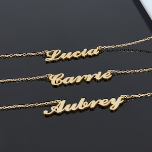 May include: Three gold necklaces with the names "Lucia", "Camrie", and "Aubrey" spelled out in cursive.