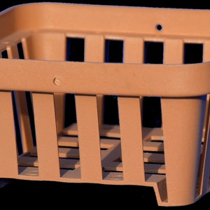 May include: A brown plastic basket with a square shape and a grid pattern. The basket is empty.