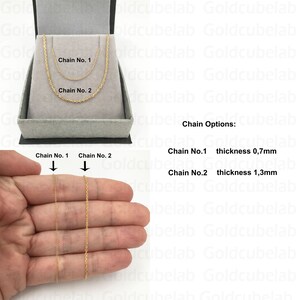 May include: Gold chain necklaces displayed in a gray jewelry box. The image shows two chain options: Chain No. 1 with a thickness of 0.7mm and Chain No. 2 with a thickness of 1.3mm. The chains are also shown held up in a hand.