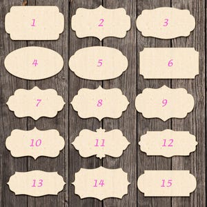 Könnte beinhalten: Fünfzehn beige Papieretiketten mit verschiedenen dekorativen Formen und lila Zahlen 1 bis 15. Die Etiketten sind auf einem dunklen Holzmaserungshintergrund angeordnet.