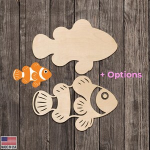 May include: Wooden fish cutouts in various styles. One is a detailed orange and white clownfish, while the others are unfinished wood. The image includes the text "+ Options" and a small American flag.