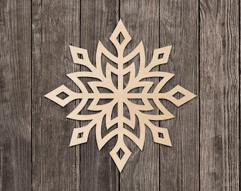 Pode incluir: Decoração de floco de neve de madeira com um design simétrico. O floco de neve é cortado de madeira clara e apresenta padrões intrincados. O fundo é uma superfície de madeira rústica. As palavras "MADE IN USA" são visíveis.