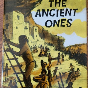 May include: A book cover illustration depicting a group of people in a Native American village. The book title is "THE ANCIENT ONES" by GORDON C. BALDWIN.