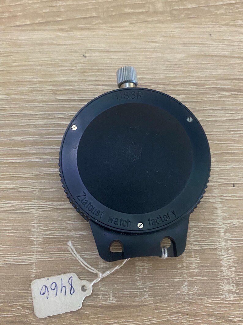 Pu&ograve; includere: Un cronometro nero della fabbrica di orologi Zlatoust con la scritta "USSR" in alto. Il cronometro ha una corona di carica argentata e una piccola etichetta con il numero "8468".