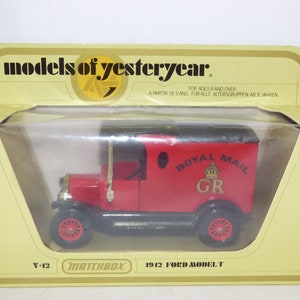 Könnte beinhalten: Ein rotes Spielzeugauto Ford Model T von 1912 mit schwarzem Dach und der Aufschrift "Royal Mail" an der Seite. Das Auto ist ein Matchbox-Modell und Teil der Serie "Models of Yesteryear".
