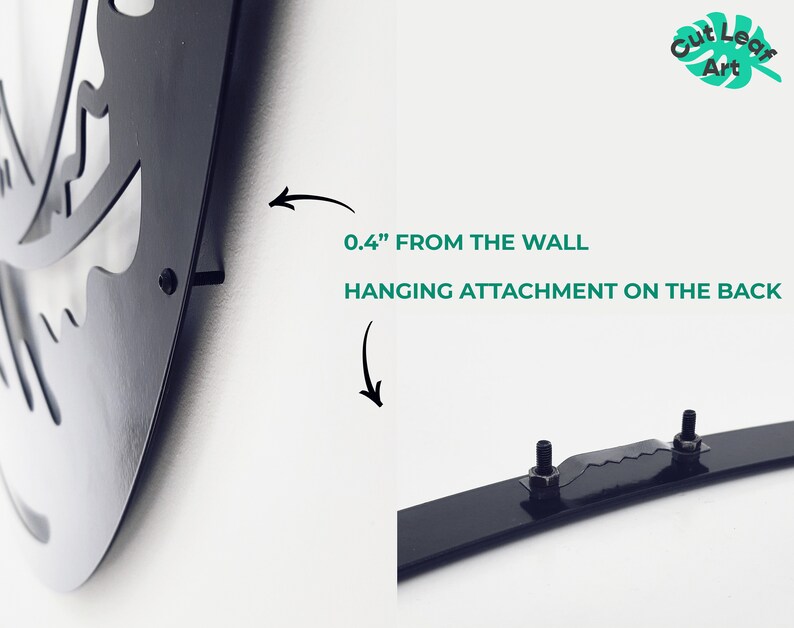 May include: Black metal wall art with a hanging attachment on the back. The attachment is 0.4 inches from the wall.