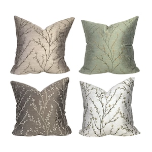 May include: Four decorative throw pillows with a floral pattern. The pillows are in shades of green, brown, and white.