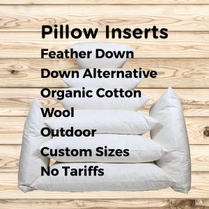 May include: A stack of white pillow inserts, with text that reads "Pillow Inserts". The pillow inserts are labeled "Feather Down", "Down Alternative", "Organic Cotton", "Wool", "Outdoor", "Custom Sizes", and "No Tariffs". The background is a light brown wood.