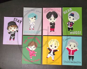 May include: Set of eight colourful cards featuring cartoon illustrations of men with different phrases. The phrases include "Stay Golden", "Never Lose Your Swagger", "World Wide Love", "I'm Your Hope", "Angelic Sweetness", "Bear Hugs", "Forever Unbreakable", and "You're My Hope".