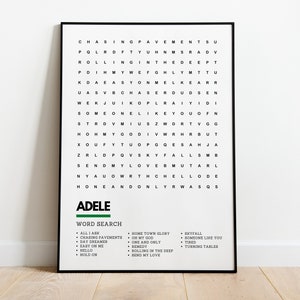 May include: A black and white word search puzzle featuring the name Adele in green. The puzzle includes song titles from Adele's albums, including "All I Ask", "Chasing Pavements", "Day Dreamer", "Easy On Me", "Hello", "Hold On", "Home Town Glory", "Oh My God", "One and Only", "Remedy", "Rolling in the Deep", "Send My Love", "Skyfall", "Someone Like You", "Tired", and "Turning Tables".