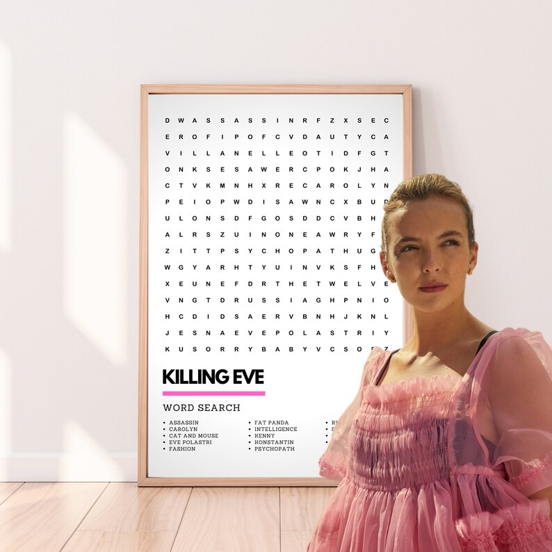 May include: A white framed poster with a word search puzzle featuring the title "Killing Eve". The poster is hanging on a wall with a pink-coloured dress in the foreground.