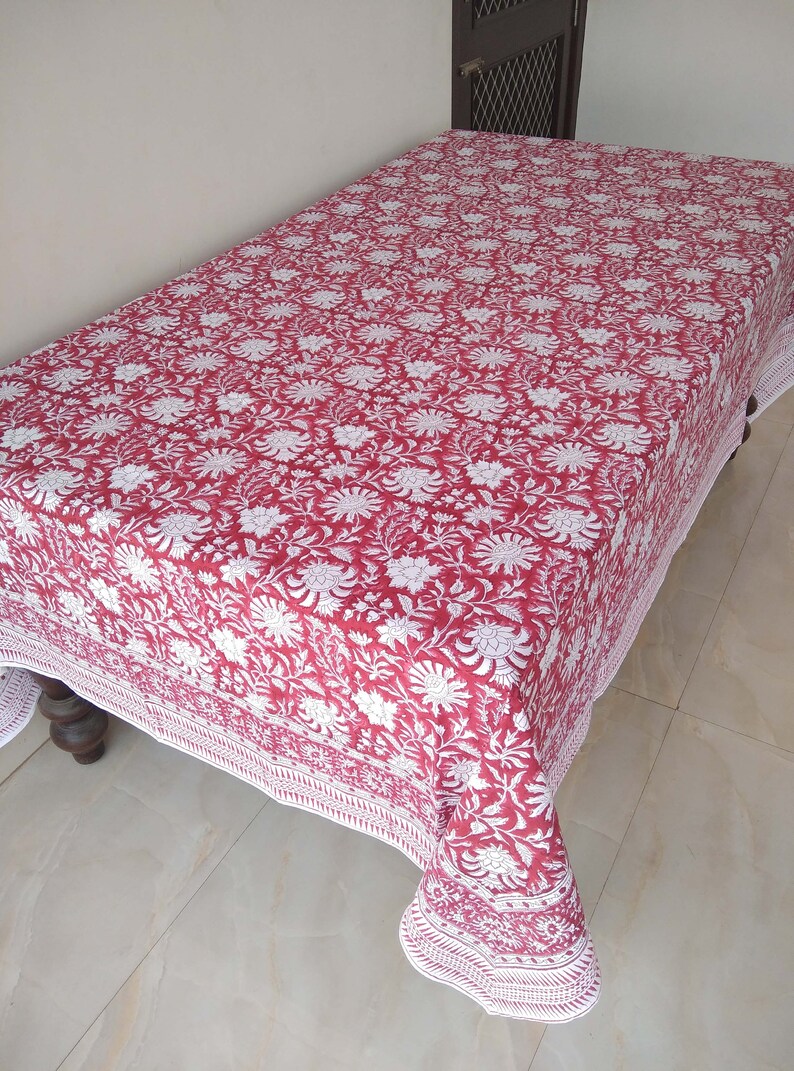 K&ouml;nnte beinhalten: Eine rote und wei&szlig;e Blumendecke mit wei&szlig;em Rand. Die Tischdecke ist aus Baumwolle und hat ein traditionelles indisches Design.