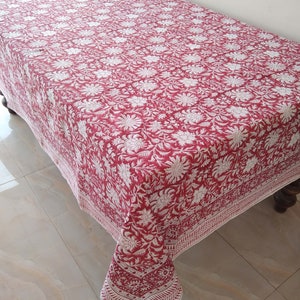 K&ouml;nnte beinhalten: Eine rote und wei&szlig;e Tischdecke mit Blumenmuster und wei&szlig;em Rand. Die Tischdecke ist aus Baumwolle und hat ein traditionelles indisches Design.