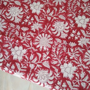 K&ouml;nnte beinhalten: Roter Stoff mit einem wei&szlig;en Blumenmuster. Der Stoff hat ein traditionelles indisches Design mit filigranen Details.