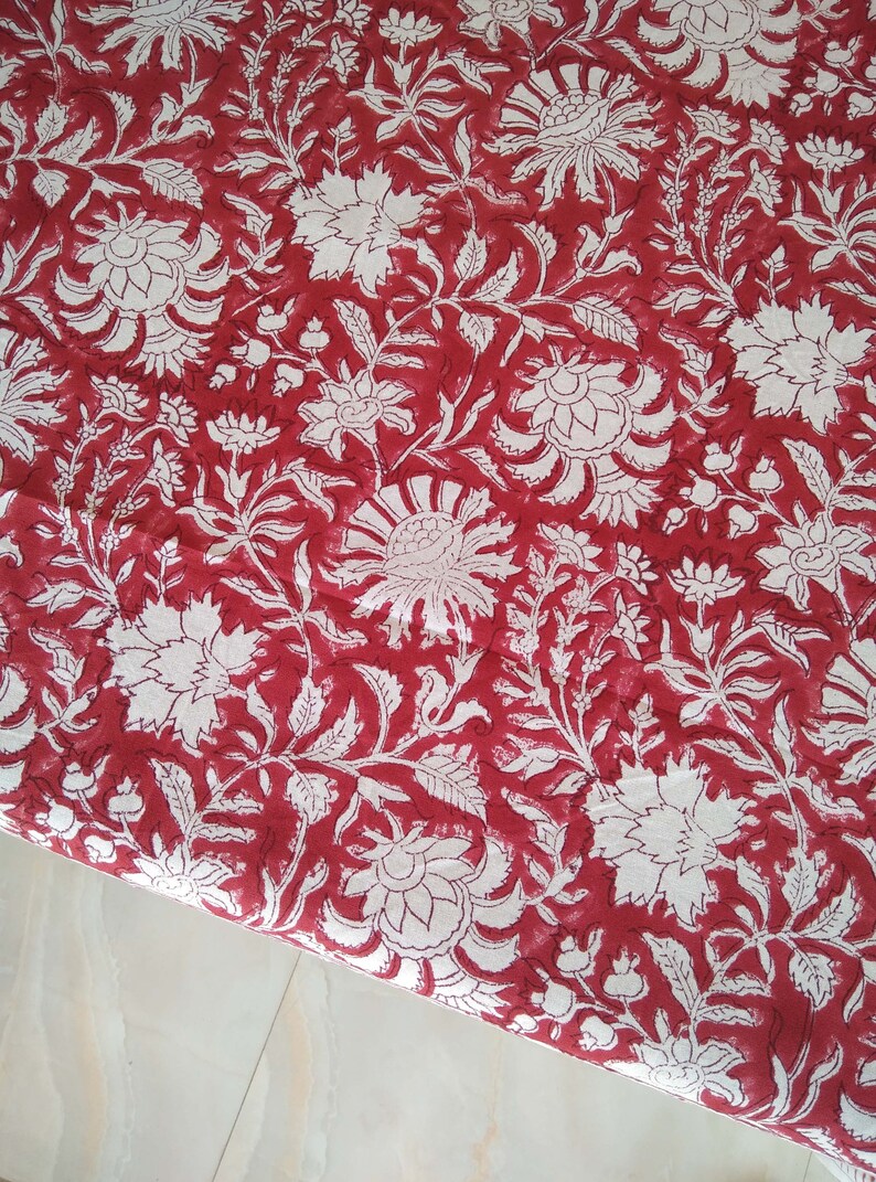 K&ouml;nnte beinhalten: Roter Stoff mit einem wei&szlig;en Blumenmuster. Der Stoff hat ein traditionelles indisches Design mit filigranen Details.