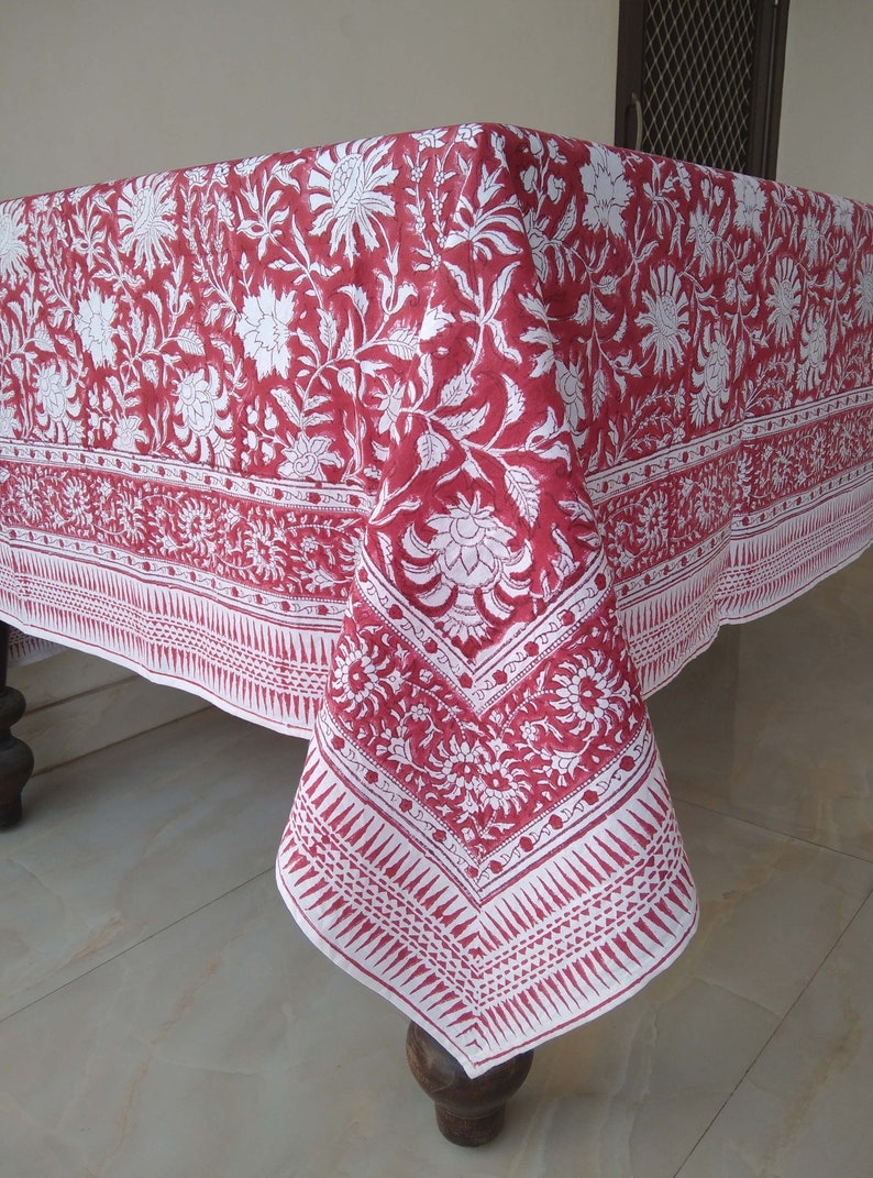 K&ouml;nnte beinhalten: Rote und wei&szlig;e Blumen-Tischdecke mit geometrischem Rand. Die Tischdecke ist aus Baumwolle und hat ein traditionelles indisches Design.