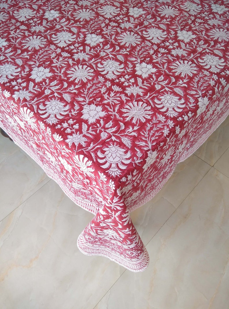 K&ouml;nnte beinhalten: Eine rote und wei&szlig;e Blumendecke mit wei&szlig;em Rand. Die Tischdecke ist aus Baumwolle und hat ein traditionelles indisches Design.