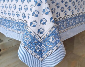 May include: A blue and white cotton tablecloth with a floral print. The tablecloth has a border with a striped pattern.