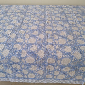 May include: A blue and white floral patterned tablecloth with a white and blue striped border.