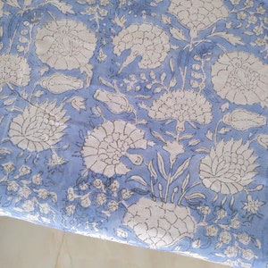 May include: A blue fabric with a white floral pattern. The fabric has a traditional Indian design with intricate details.