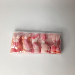Puede incluir: Un paquete de gominolas rosadas y blancas con forma de figuras humanas.