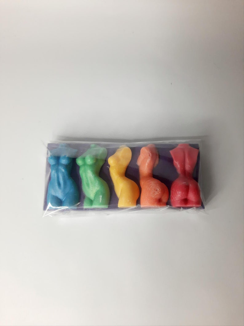 Puede incluir: Cinco peque&ntilde;as figuritas de colores con forma humana en un esquema de colores arco&iacute;ris. Las figuritas est&aacute;n dispuestas en fila sobre un fondo morado.