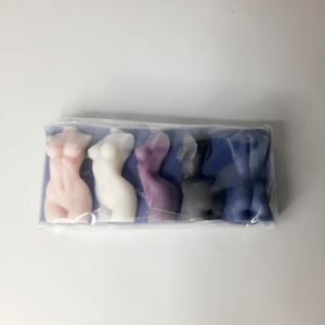 Puede incluir: Cinco peque&ntilde;as figuritas de cera de color vivo con forma humana. Las figuritas est&aacute;n dispuestas en fila sobre un fondo azul. Las figuritas son rosa, blanca, morada, gris y azul.