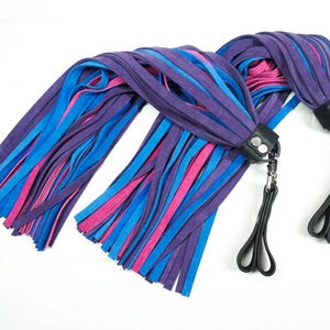 May include: Two blue, pink, and purple leather whips with black leather handles and silver chains.