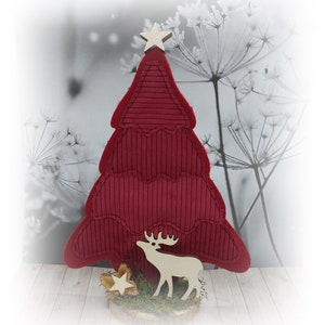 May include: A red felt Christmas tree with a wooden star on top and a wooden reindeer standing in front of it. The tree is on a wooden base with moss and a small wooden star.