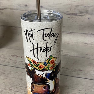 This stainless steel tumbler says not today heifer on one side with a cow wearing a bandana and on the other side it says not my pasture not my bullshit, the bottom is a yellowish gold.  these are wonderful skinny tumblers