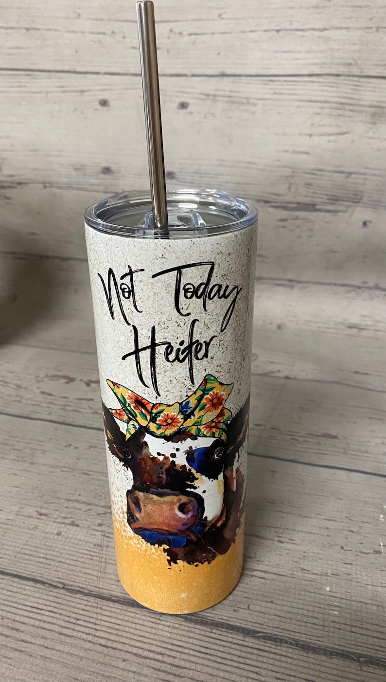 This stainless steel tumbler says not today heifer on one side with a cow wearing a bandana and on the other side it says not my pasture not my bullshit, the bottom is a yellowish gold.  these are wonderful skinny tumblers