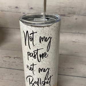 This stainless steel tumbler says not today heifer on one side with a cow wearing a bandana and on the other side it says not my pasture not my bullshit, the bottom is a yellowish gold.  these are wonderful skinny tumblers