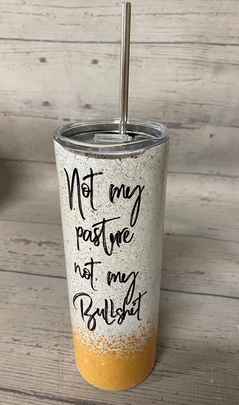 This stainless steel tumbler says not today heifer on one side with a cow wearing a bandana and on the other side it says not my pasture not my bullshit, the bottom is a yellowish gold.  these are wonderful skinny tumblers