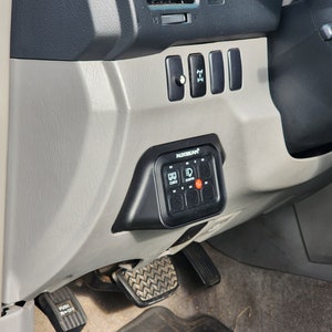 May include: A black switch panel with the text "RADIOSHACK" and multiple buttons. The panel is mounted on the dashboard of a vehicle.