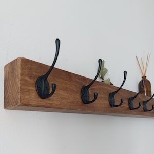 Minimalist chunky solid wood coat rack and display shelf with black industrial hooks covering pre-drilled holes, for narrow hallway, mudroom