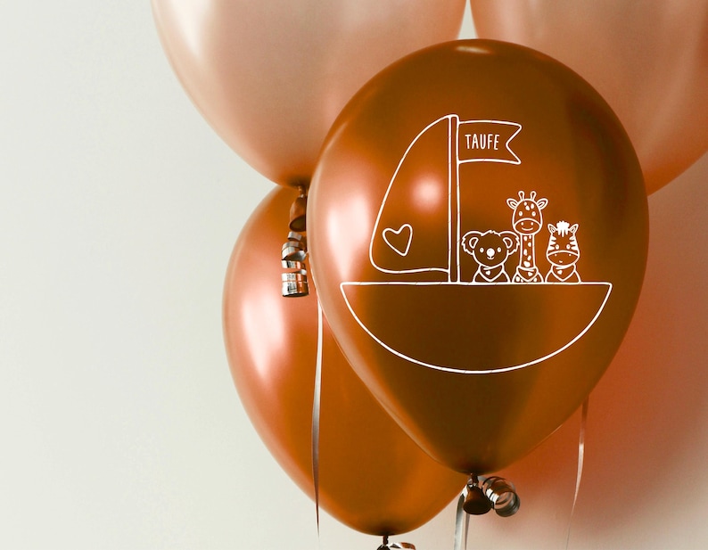 K&ouml;nnte beinhalten: Drei kupferfarbene Ballons mit einem wei&szlig;en Design eines Bootes mit einer Giraffe, einem Zebra und einem B&auml;ren. Der Ballon in der Mitte tr&auml;gt das Wort "Taufe".