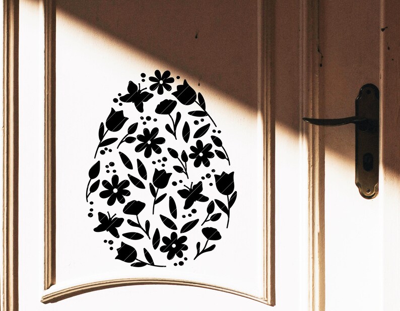 Puede incluir: Una silueta negra de un huevo de Pascua con un dise&ntilde;o floral. El huevo est&aacute; lleno de flores, hojas y mariposas.