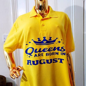 May include: Yellow polo shirt with a blue crown and the text "Queens are born in August".