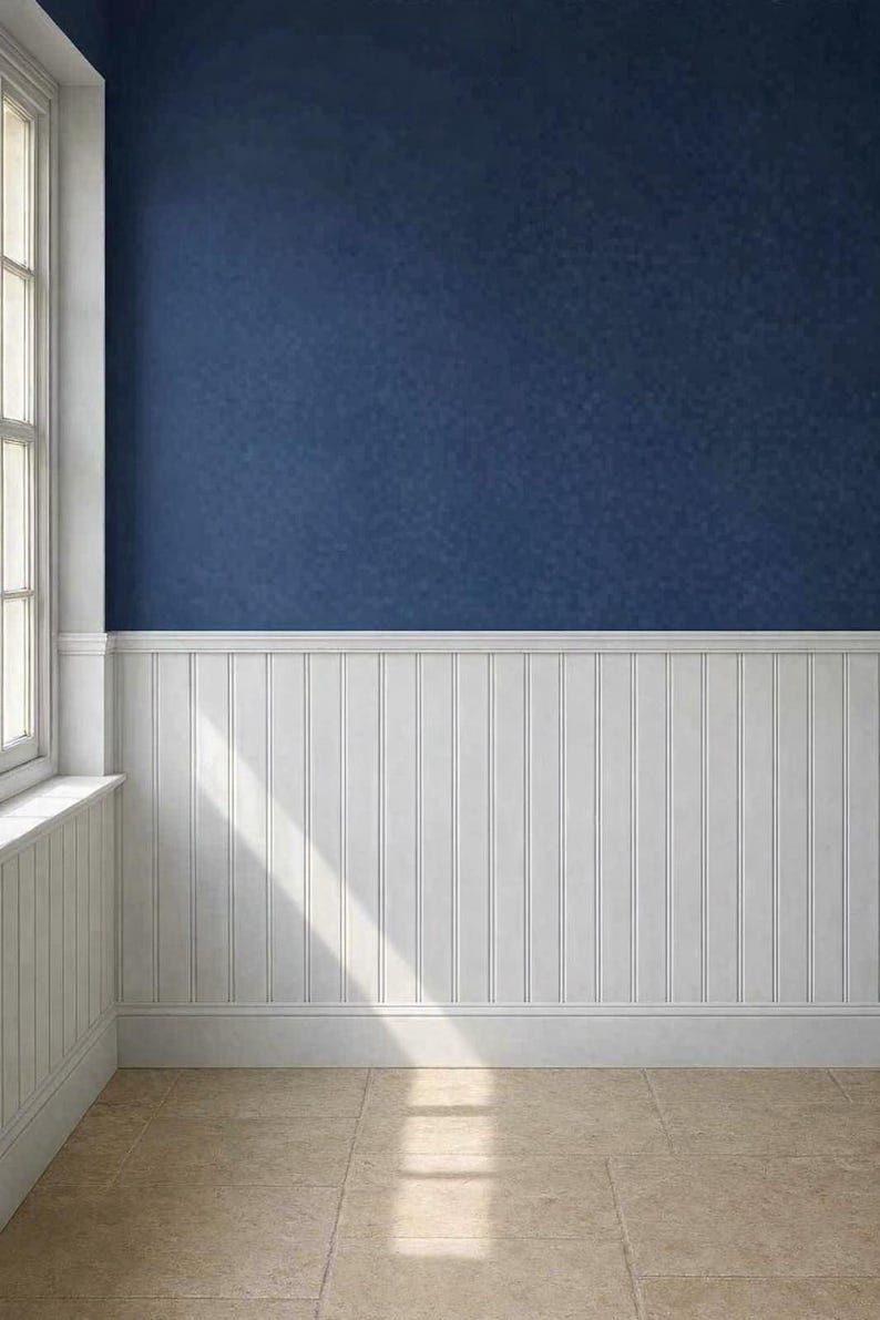 May include: Interior shot of a room with a navy blue textured wall above white wainscoting. A window with white trim is visible on the left. The floor is tiled in a light beige color. Sunlight streams across the floor.