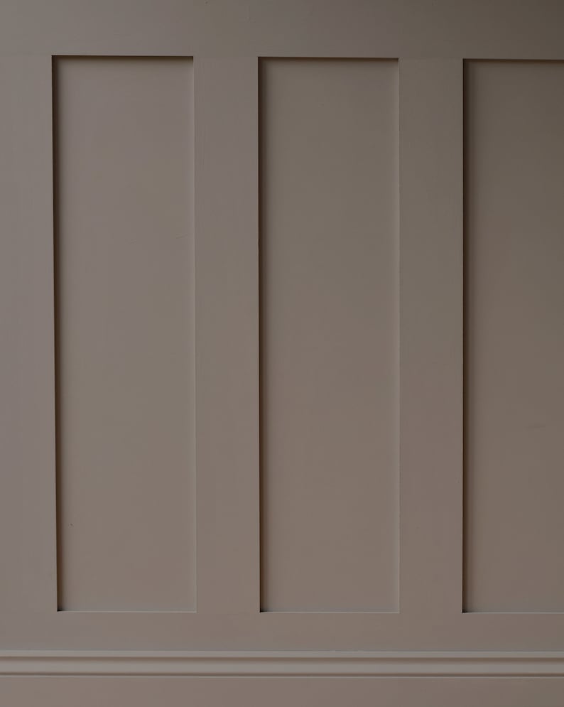 May include: A wall with three vertical panels, each painted a light brown color. The panels are separated by thin white lines.