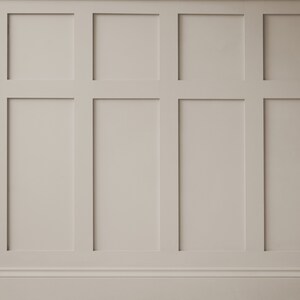 May include: A white wall with a raised panel design. The panels are arranged in a grid pattern, creating a classic and elegant look.