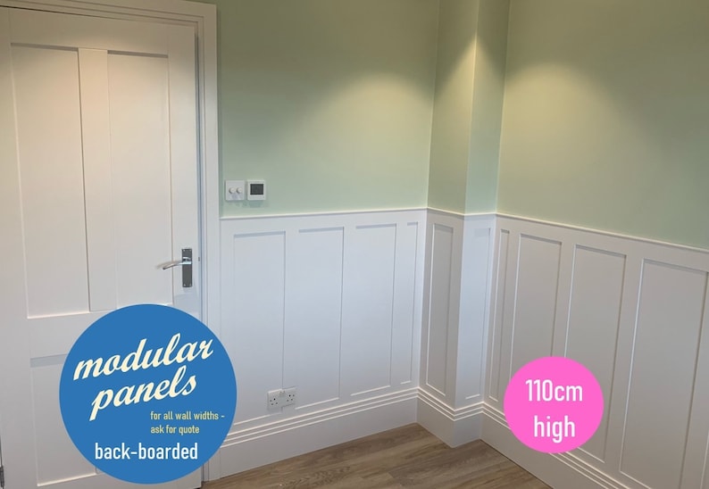May include: White wall panels with a raised design, back-boarded and measuring 110 cm high. The panels are installed in a room with a light green wall and a white door.