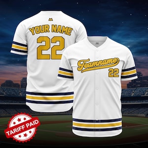 May include: White baseball jersey with navy and gold stripes and accents. The jersey features the text "Your Name" and the number "22" on the back, and "Teamname" and "22" on the front. The jersey has a button-up front.