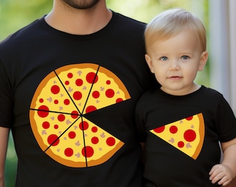 May include: A black t-shirt with a pizza graphic on it. The pizza has pepperoni and mushrooms. A smaller black t-shirt with a slice of pizza on it. The shirts are worn by a man and a child.
