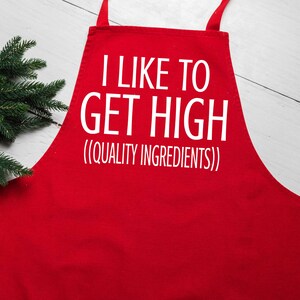 Puede incluir: Delantal de cocina rojo con texto blanco que dice "Me gusta ponerme high (ingredientes de calidad)".