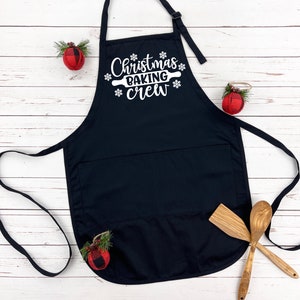 May include: Black Christmas baking apron with a white design that says "Christmas Baking Crew" with a rolling pin and snowflakes.